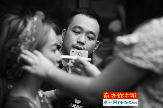网红培训师大新正在指导网络女主播化妆,并用手机记录下来。