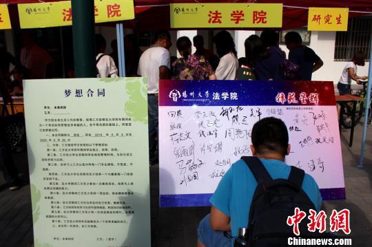 图为一名大一新生报到签“梦想合同”。 (王馨钰/摄)