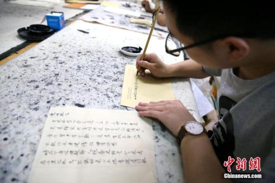 5月21日,在陕西咸阳师范学院于右任书法学院内,数十名大学生手执毛笔用小楷书写着家书。张远 摄