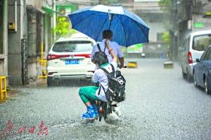 家长冒雨骑车送孩子上学,女孩贴心地把伞往他身上靠。广州日报全媒体记者陈忧子摄