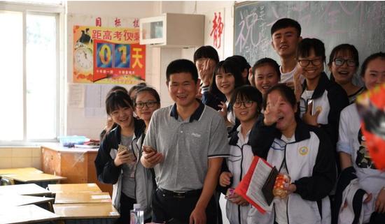 学生与老师合影留念,告别自己的高中生涯。