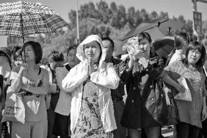 考生进场后,家长在考场外祈福