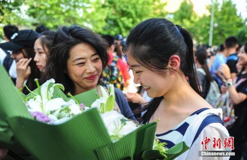 资料图:山东济南众多考生手捧鲜花在家长的簇拥下欢快告别高考。中新社记者 张勇 摄