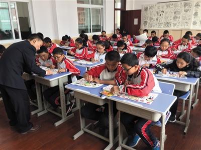 西藏日喀则市,上海实验学校的援藏教师高群斌在给藏族学生上美术课。