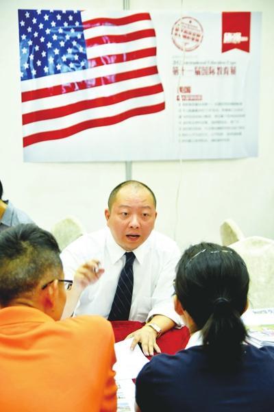 2012年6月24日,在杭州举办的第十一届国际教育展上,一名国外高校的招生老师(中)在做留学咨询。图片来源 CFP