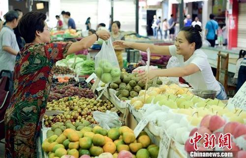 资料图:民众正在购买水果。中新社记者 刘忠俊 摄