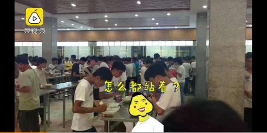 8月26日中午,河南睢县高中食堂内学生站着吃午饭。图片/梨视频截屏