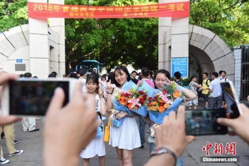 资料图:2018年高考结束,家长为刚刚走出考场的孩子拍照留念。 王以照 摄