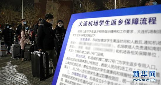 1月20日凌晨,大连理工大学的学生们在校园里排队准备乘车。新华社记者 姚剑锋 摄