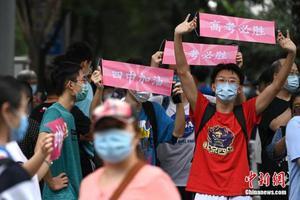 资料图:2020年7月10日,北京高考最后一日,部分2019届北京四中毕业生手持加油横幅,为学弟妹们加油打气。中新社记者 崔楠 摄