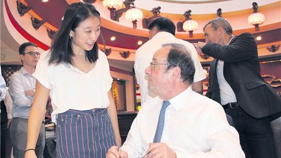 曾永革的女儿Claire在法国前总统奥朗德新书签售会上与其交谈。(图片来源:曾永革 摄)