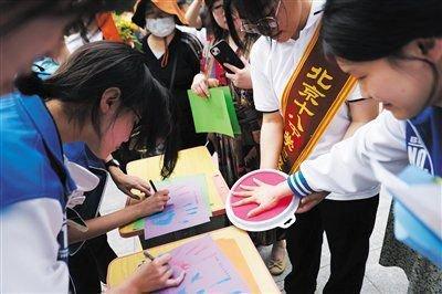 6月10日,北京市第十八中学考点,考生在纸上印上自己的掌印并在掌印旁写上送给自己、家人和老师的祝福。新京报记者 李木易 摄