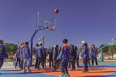 2023年,四川稻城的小学生们在壹基金帮助修建的篮球场上打球。 受访者供图