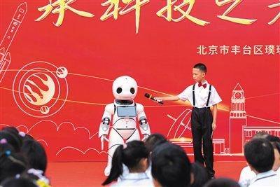 9月1日,北京市丰台区璞瑅学校开学典礼现场,智能机器人“小科”和小主持人进行互动。受访者供图