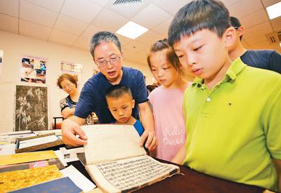 学生们在老师指导下参观复旦大学中华古籍保护研究院收藏的古籍珍品。陆嘉辉摄