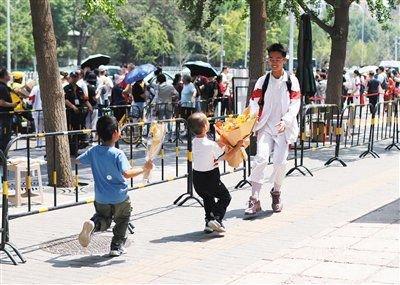 6月10日,人大附中考点,小朋友为结束高考的表哥送上鲜花。 新京报记者 浦峰 摄