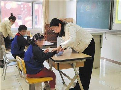 12月3日,北京市盲人学校老师在综合康复课上教学生剥豌豆。新京报记者 杨菲菲 摄