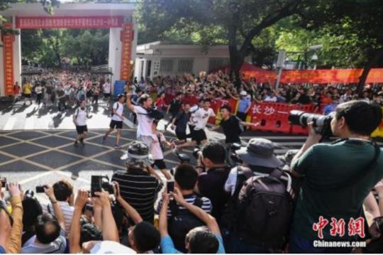 资料图:6月8日下午,湖南长沙市一中考点外,考生跑出考场,庆祝高考结束。 中新社记者 杨华峰 摄