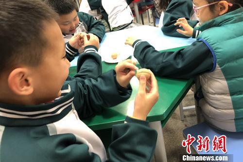 用核桃比作宝宝在妈妈怀孕某个阶段的直观大小,吸引孩子专注于课堂。汤琪 摄