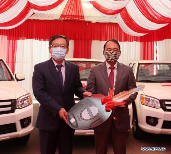 Chinese Ambassador to Cambodia Wang Wentian (L) symbolically hands over a car key to first Vice President of the Cambodian Mine Action and Victim Assistance Authority (CMAA) Ly Thuch at a ceremony in Phnom Penh, Cambodia, Jan. 19, 2021. China donated mine-clearance equipment and devices as well as vehicles to the CMAA on Tuesday. (Photo by Sovannara/Xinhua)
