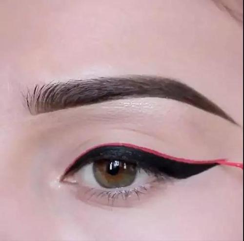 Step2:再用细细的彩色眼线液笔,顺着黑色眼线的上端勾出上扬的形状。