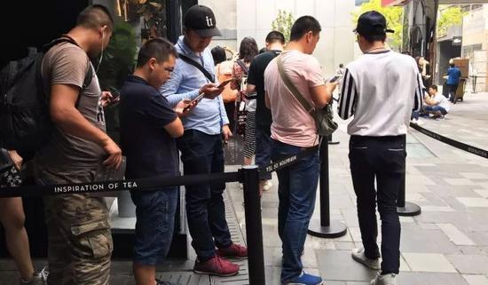 带着耳机,盯着手机,黄牛特意指了指排在队伍里的“伙伴”们