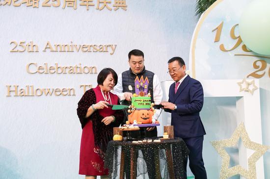婕妮璐创始夫妇卢旭东、王建平和他们的儿子卢琦(中)在庆典现场切蛋糕
