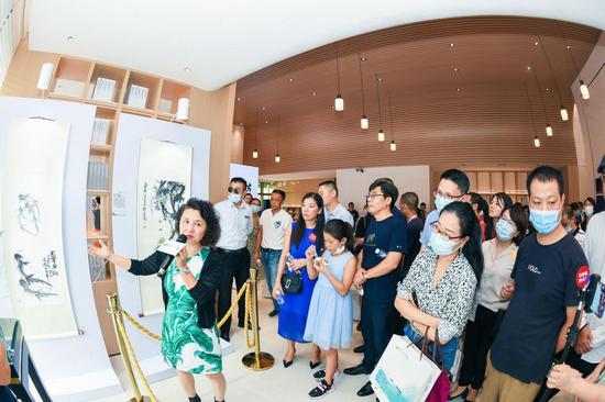 齐艳芳在现场为市民讲解齐家作品及技法特色(左1为齐艳芳《长年有余》-2017)