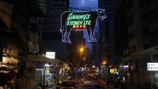 在香港西区,在今年八月前,一个牛排餐厅门口悬挂的牛形霓虹招牌一直是这个地方的地标。屋宇署认为它不安全,于是把它拆了。图片来源:Herbert Buchsbaum/《纽约时报》