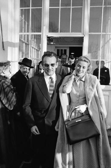 1956年,用Hermès包袋遮住微微隆起的小腹的Grace Kelly
