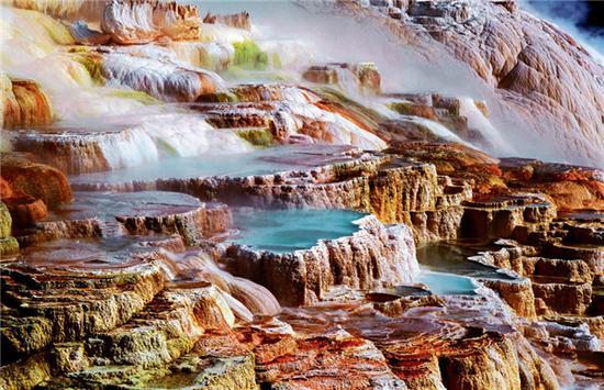 黄石国家公园北门的猛犸热泉(Mammoth Hot Spring)是世界上最大的碳酸盐沉积泉,热泉从山坡上一层层流淌下来,形成五彩的大阶梯。