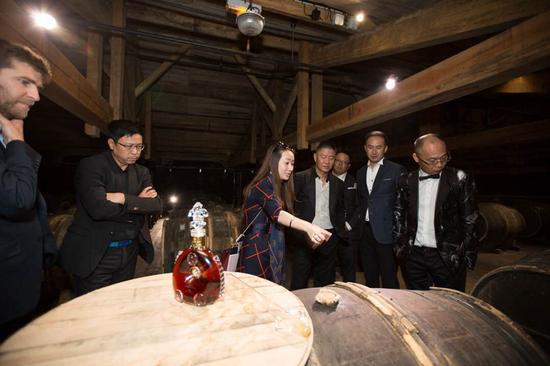 路易十三传讯经理史佳琼(左三)向好友们介绍用于陈酿生命之水的专属蒂尔肯橡木桶。它由树龄达150年的利木赞橡木制成,是成就路易十三传奇的独特珍宝,除路易十三之外任何干邑都无此殊荣。