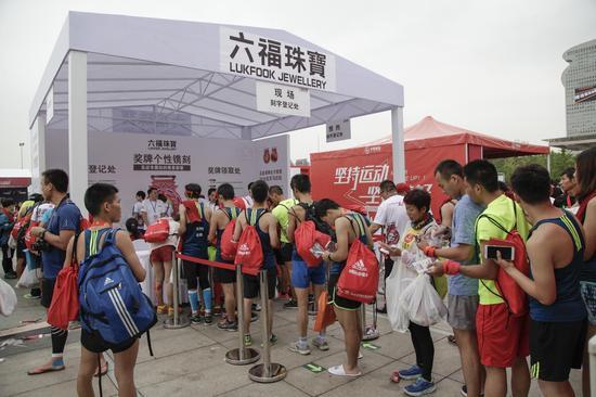 终点处六福珠宝展台,免费为跑手们进行奖牌刻字服务