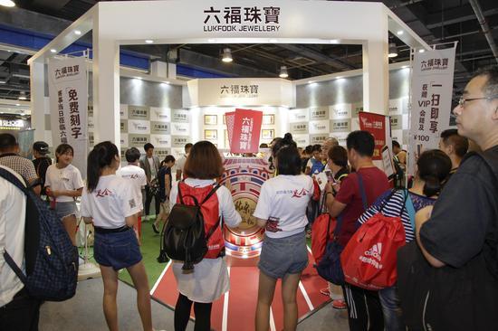 六福珠宝展台跑手争先恐后地和奖牌大道具合影留念