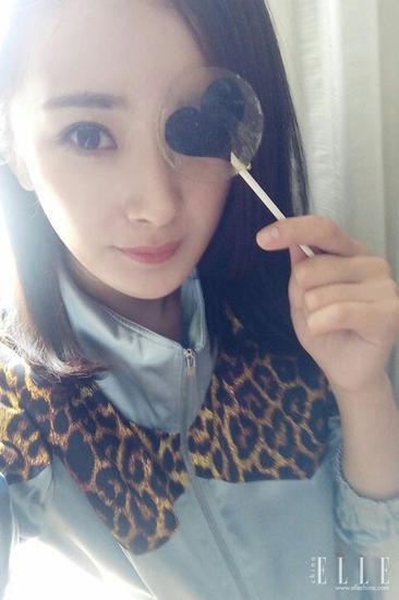 杨幂拿一支棒棒糖来遮眼
