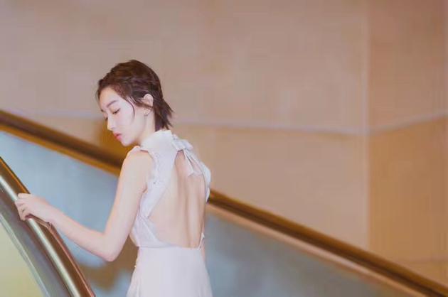 周冬雨身着Miu Miu 2017秋冬系列珍珠装饰白色连身短裙和高跟鞋,佩戴Didier Dubot高级珠宝亮相时尚活动。