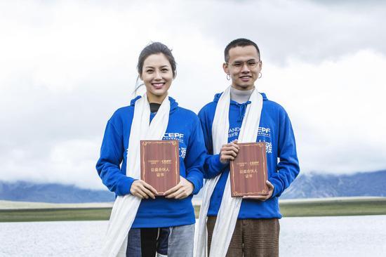 知名艺人艾克里里(右)、模特演员张昊玥(左)在日喀则自然堂草场被授予“自然堂喜马拉雅公益合伙人”证书