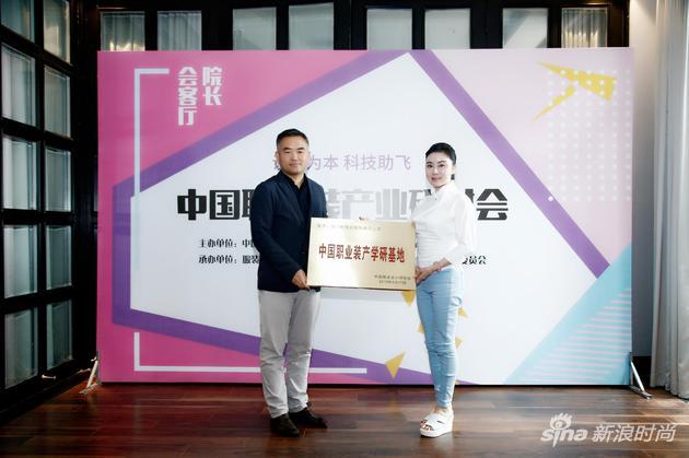 中国服装设计师协会主席张庆辉将“中国职业装产学研基地”称号名牌授予厦门优佳丽集团黎姿职业装创意中心(右为陈黎明董事长)
