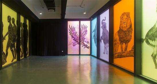 作品名称:《注意》作者:墨府小组 材质:PVC材料上丙烯水墨 尺寸:395*270cm 年代:2019 恩斯特·卡西尔说:‘人是符号的动物。’人类使能够描述无法摸、看、听到的事物,人类创造语言、创造符号,由而诞生宗教、哲学、政治、艺术、文学。。。人类的这一特殊能力,使人类得以区别于地球上其他动物,使得人类拥有了非凡的身份地位和历史使命。而人类这一特殊的能力,也必将反作用于自身。 作品以日常生活中司通见惯的警示牌符号为创作原型,选取个别具有典型代表意义的警示牌符号,将其图案还原至它所指的真实的形象,将“泛指”转为“特指”,将“概念”还原至“具体”,将“示意”还原到“现实”。试图通过上述方式,思考并探讨‘我们何以创造符号?符号又何以改造我们?’的问题,探寻“现实”、“符号”与“认知”三者间的关系。 ‘我们必须继续下去,只要还有思考和讨论,我们必须创造符号,创造新的语言、新的艺术、新的文学。我们不断地创造符号,直到符号找到我们、创造我们。’