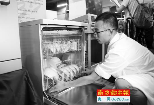 实验人员现场演示家用洗碗机测试情况。