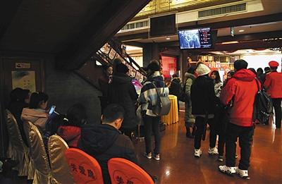 除夕夜,老字号全聚德前门店,等待翻台吃年夜饭的客人在门口排队等着叫号。