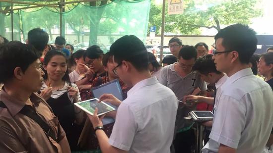 为了加快流程进度,民生银行的工作人员出了大门,提前预审、拍照。据现场人员透露,当天下午三点半,也才完成了100多号。