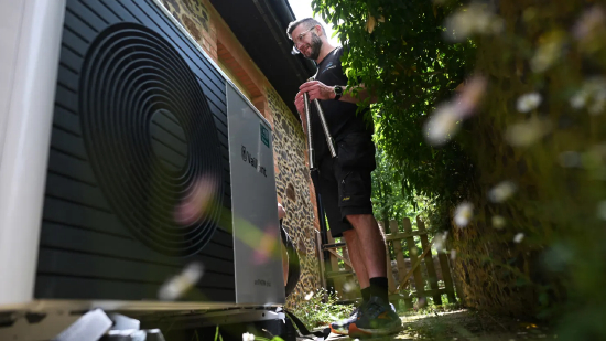 2025 年 6 月 2 日，在伦敦西南部萨里郡法纳姆的一处住宅内，莲花能源公司的热泵安装工理查德・威尔金斯正在为威能 aroTHERM plus 型热泵接管拧固。