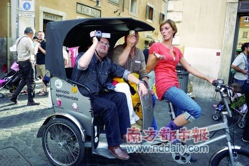 一名女车夫担任三名外籍游客的导游,并且骑车载他们游览。 一名女车夫担任三名外籍游客的导游,并且骑车载他们游览。