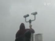 工作人员冒着13级大风 擦拭天气现象仪镜头