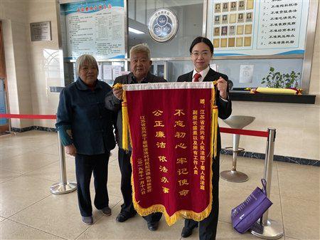 上图:原告向法官赠送锦旗。