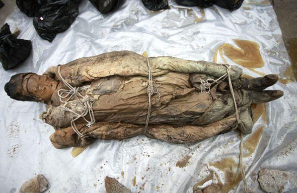 女尸被紧紧地裹在蜡布、衣服和被子中。 女尸被紧紧地裹在蜡布、衣服和被子中。