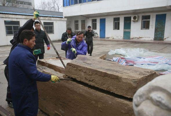 石棺发现于泰州一处工地的墓穴中,墓穴中共有三个石棺。考古学家小心翼翼地撬开石棺的棺盖 石棺发现于泰州一处工地的墓穴中,墓穴中共有三个石棺。考古学家小心翼翼地撬开石棺的棺盖