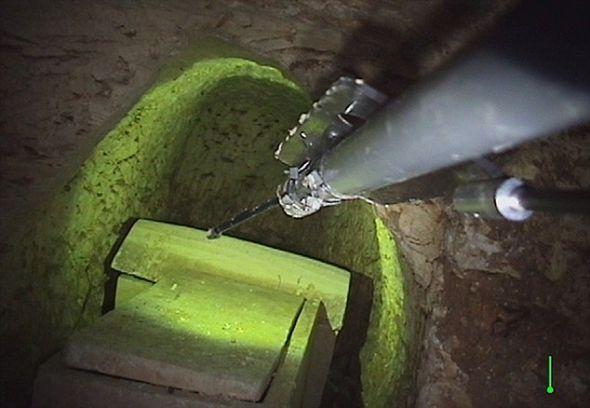 研究小组利用装在这条机械臂上的远程遥控摄像机对墓室进行探测 研究小组利用装在这条机械臂上的远程遥控摄像机对墓室进行探测