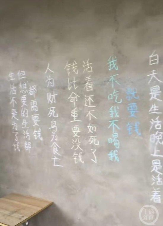 ▲墙上写满了“钱比命重要”等各种文字。